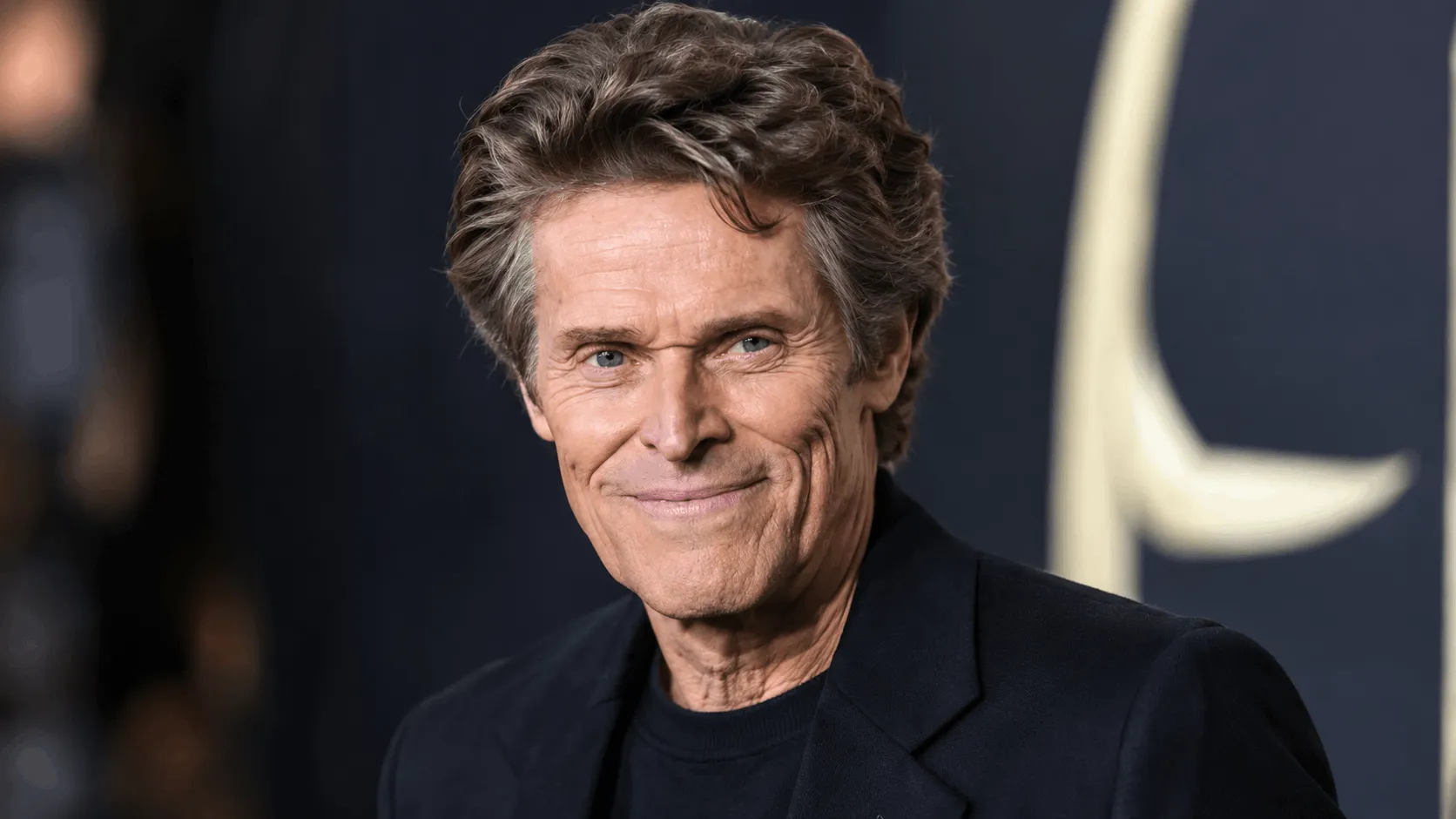 Willem Dafoe net worth 2026 photo at a film premiere